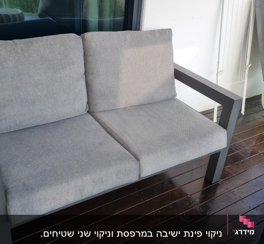 ספה אפורה על מרפסת עץ עם פסל כבשה